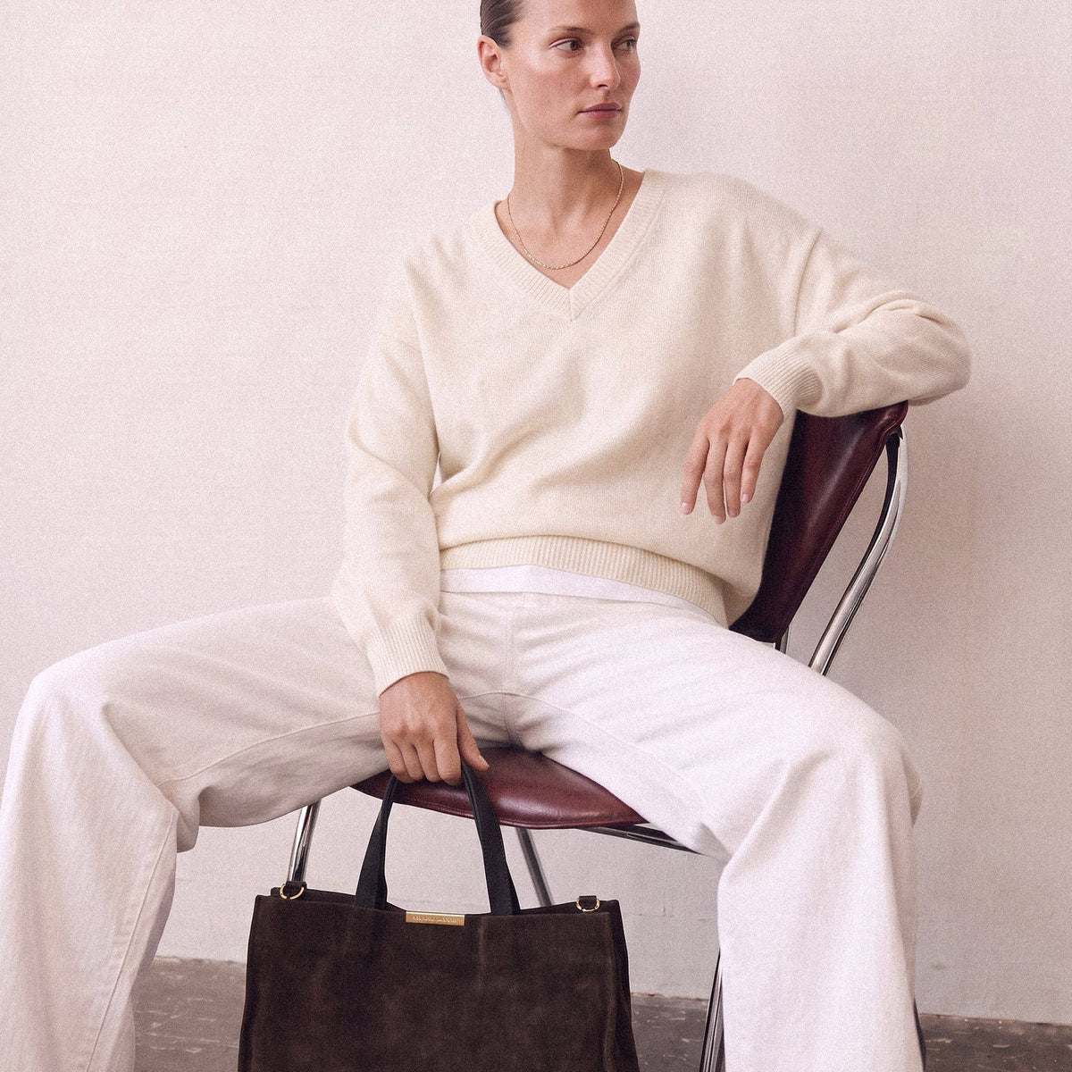 Brown outfit for winter: a cream sweater and white jeans with the Capri Satchel in Chocolate