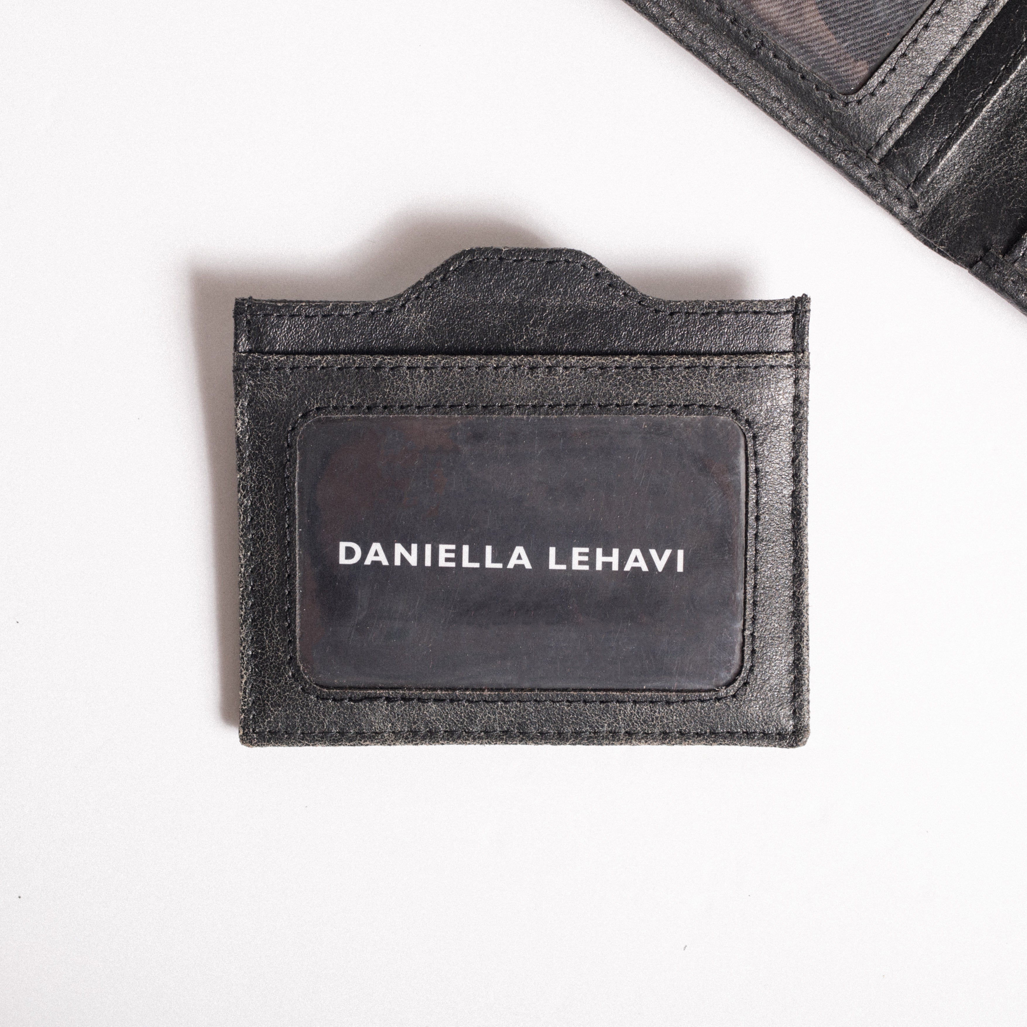 מחזיק כרטיסים מעור שחור עם הכיתוב DANIELLA LEHAVI, על רקע לבן.