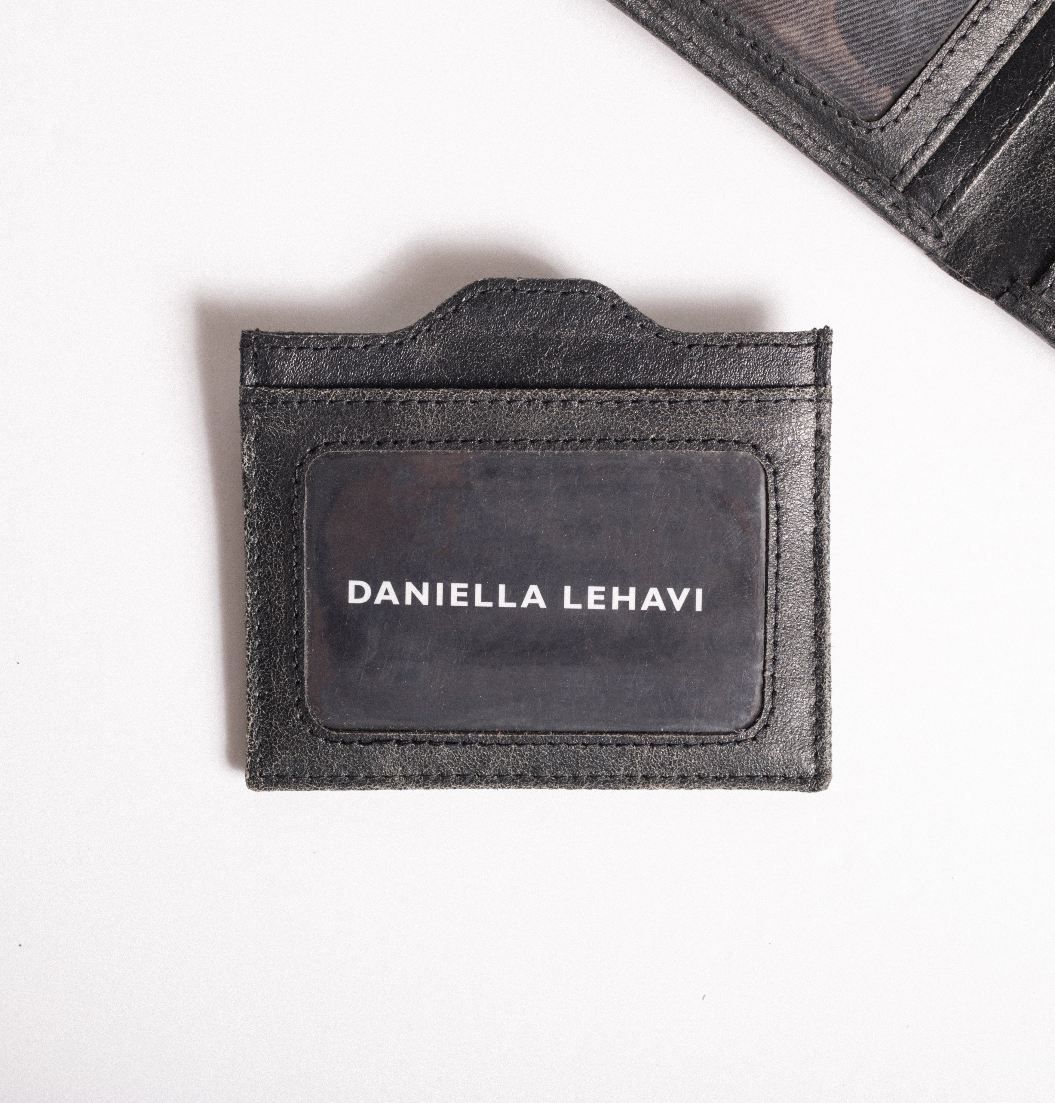מחזיק כרטיסים מעור שחור עם הכיתוב DANIELLA LEHAVI, על רקע לבן.