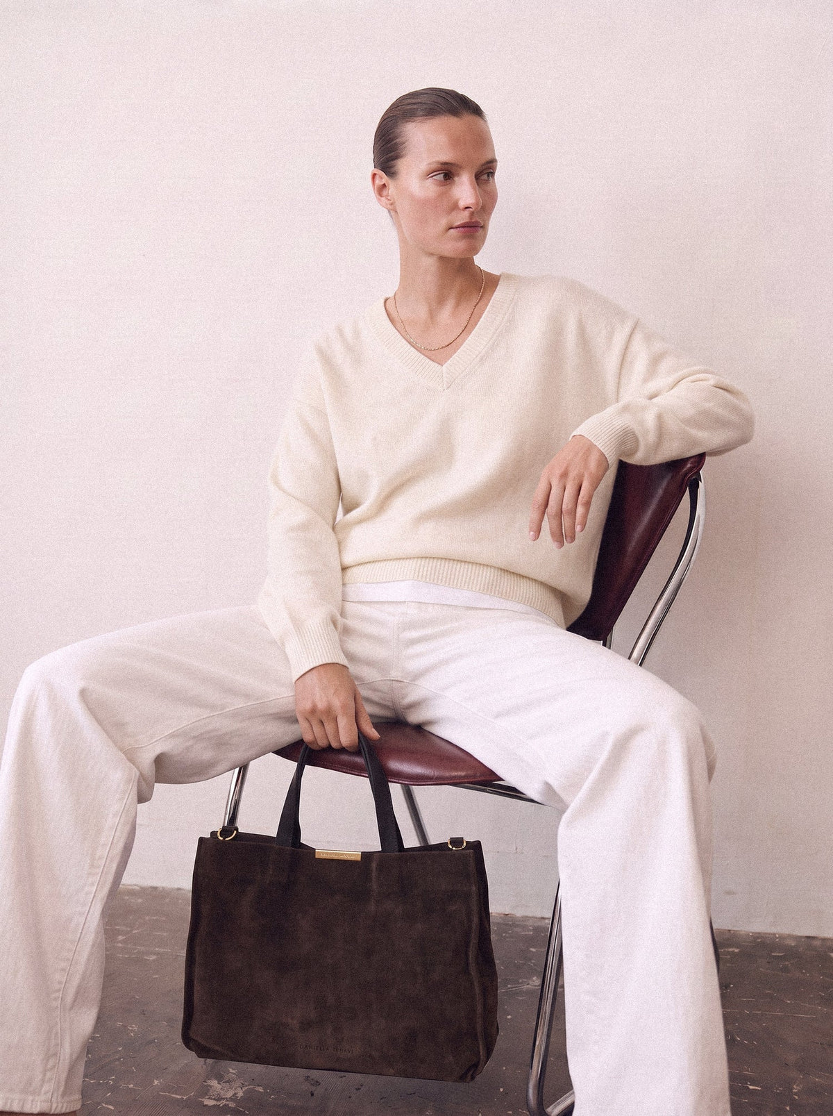 Brown outfit for winter: a cream sweater and white jeans with the Capri Satchel in Chocolate